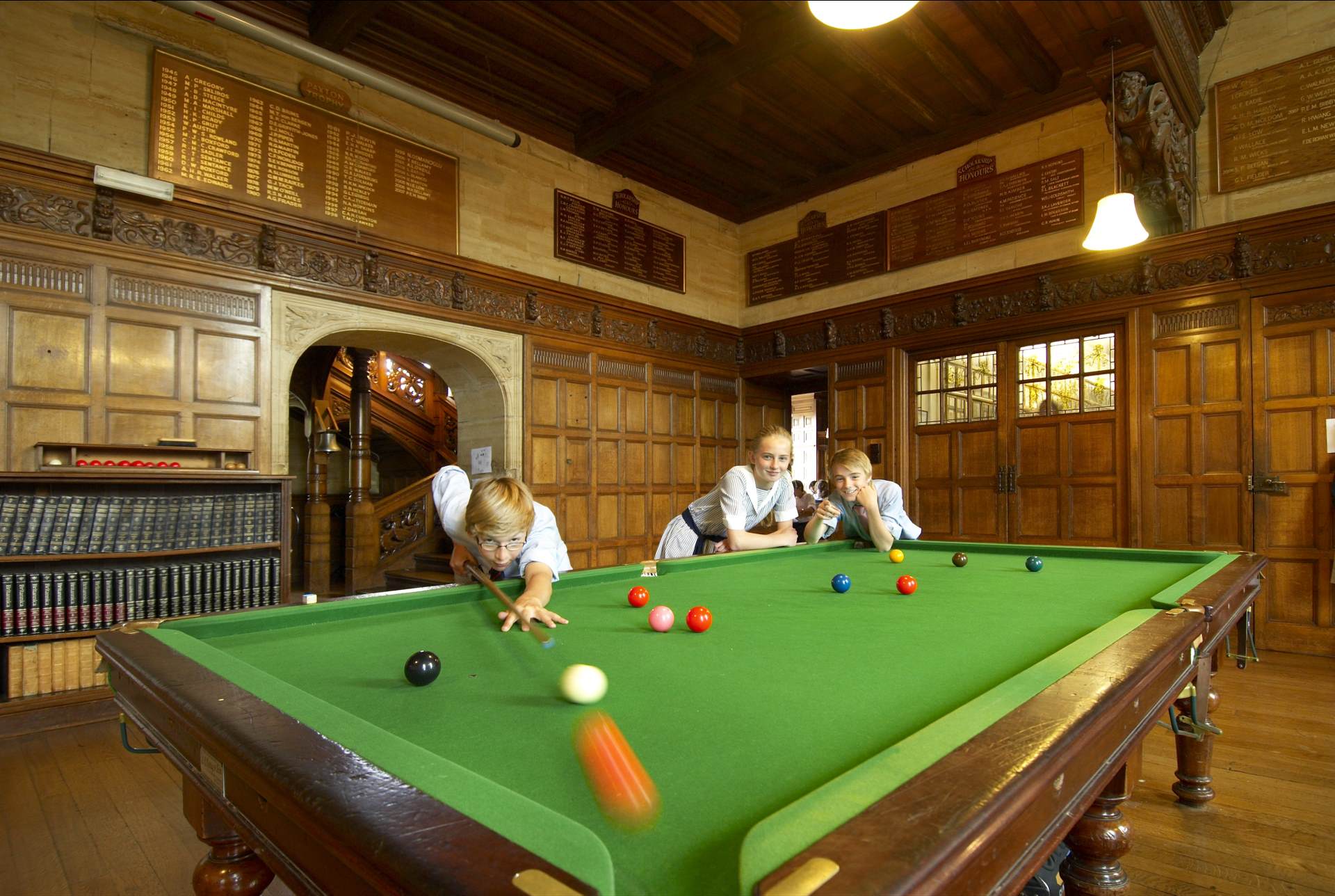 cottesmore school pupils playing snooker action shot on table potting orange ball