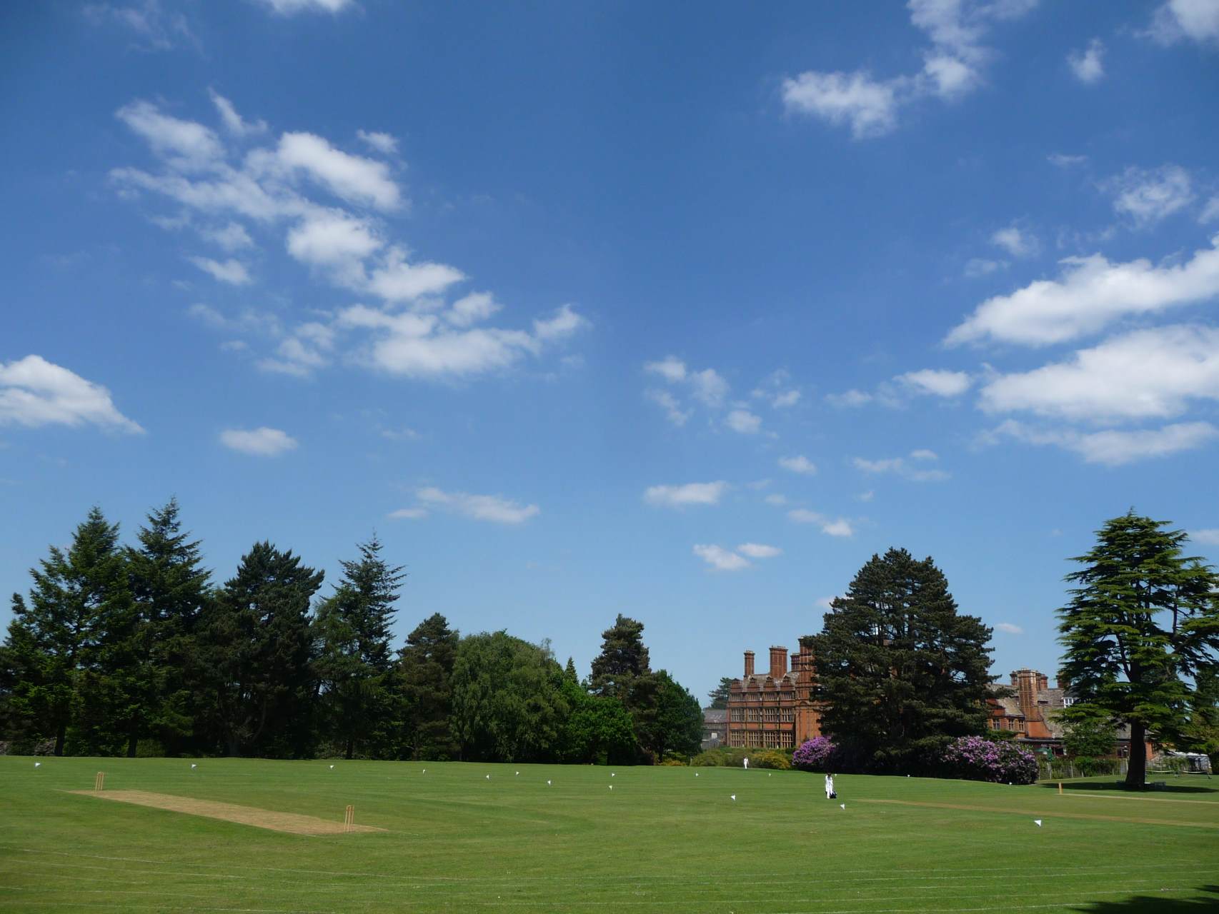 cottesmore school panoramic view of cricket pitch grounds with school building in background and trees