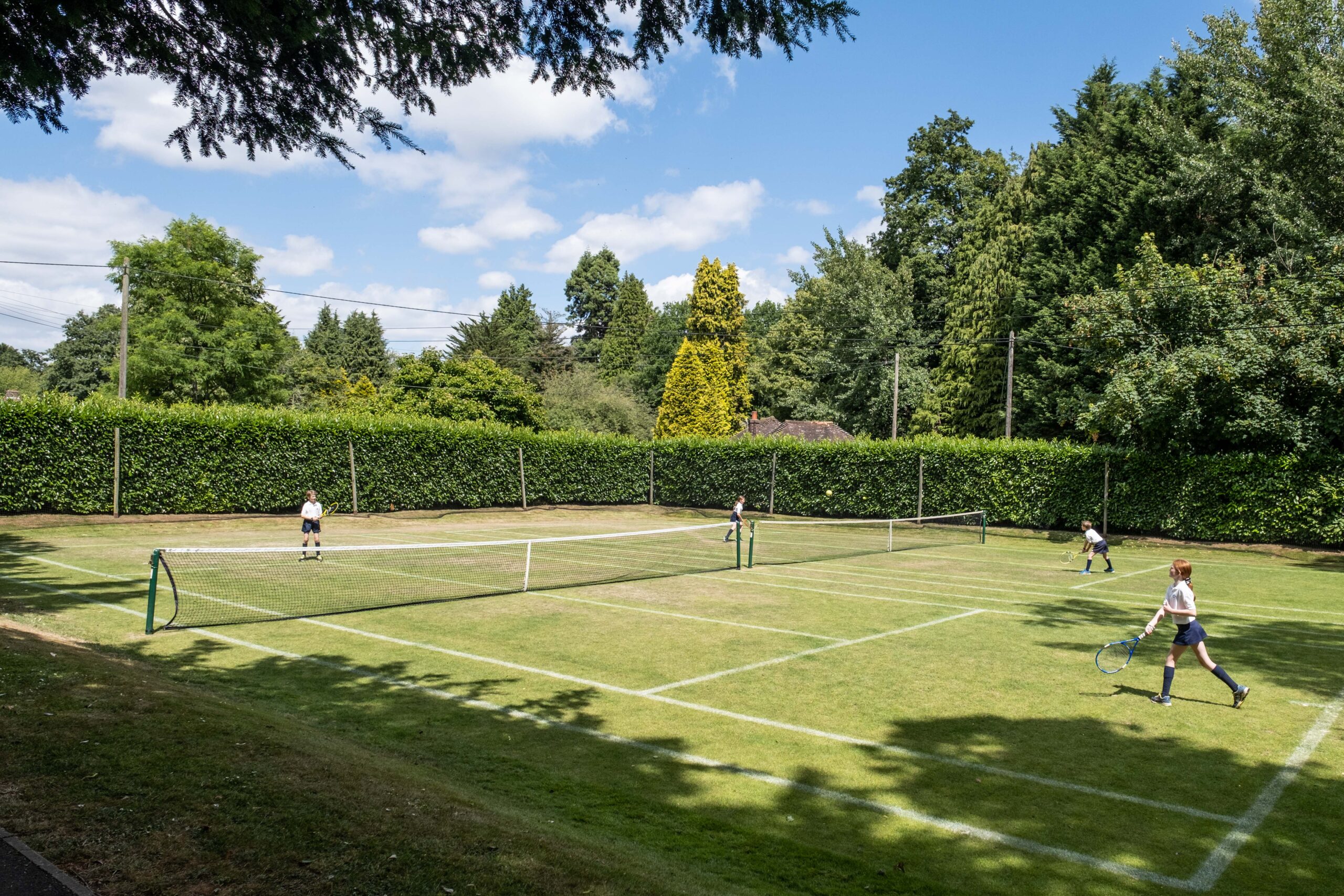 Cottesmore school pupils playing tennis on the grass courts